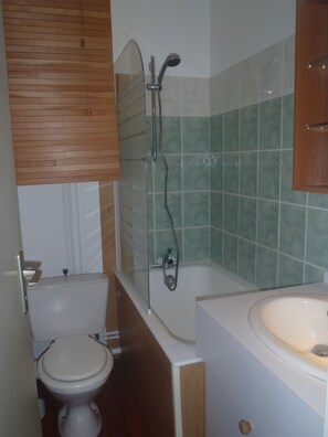 Ein Badezimmer mit Toilette, einer Badewanne und einer Duschkabine.