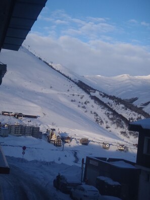 A snow-covered mountain landscape with buildings and a ski lift.