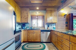 A kitchen with wooden cabinets, a stainless steel refrigerator, a dishwasher, and a granite countertop. - 2BR with loft retreat with mountain views, hot tub (Snoqualmie Pass)