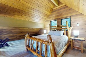 A wooden cabin bedroom with a bed, two windows, and a nightstand. - 2BR with loft retreat with mountain views, hot tub (Snoqualmie Pass)