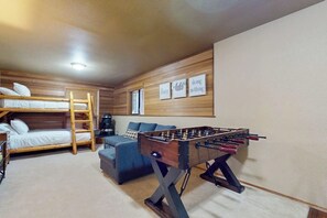 A room with bunk beds, a sofa, and a foosball table. - 2BR with loft retreat with mountain views, hot tub (Snoqualmie Pass)