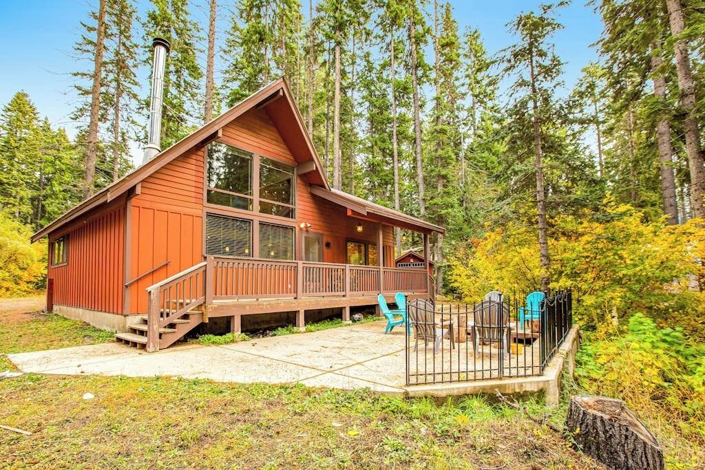 Eine Hütte mit einer Terrasse, umgeben von Bäumen.