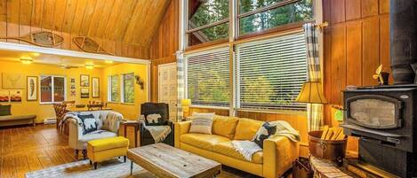 Una sala de estar acogedora con chimenea, pisos de madera y ventanas amplias.