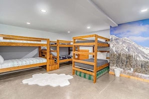 A room with bunk beds, a mountain mural, and a white fur rug. - Mountain 4BR with hot tub, game room & fireplaces (Snoqualmie Pass)