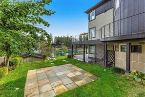 A modern two-story house with a covered patio, a swimming pool, and a well-maintained lawn. - 5BR luxury lake home with private beach & dock (Fox Island)