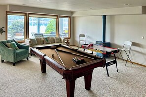 A pool table in a room with a sofa, chairs, and large windows. - 3 BR Waterfront home with beach access (Shelton)