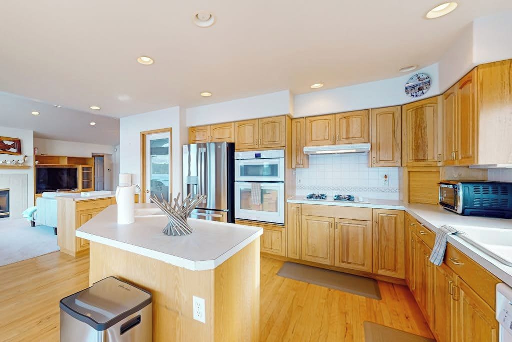 A modern kitchen with wooden cabinets, stainless steel appliances, and a central island.