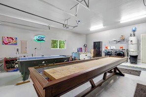 Ein Billardraum mit Billardtisch, Flipperautomaten und einem weiteren Flipperautomaten.
