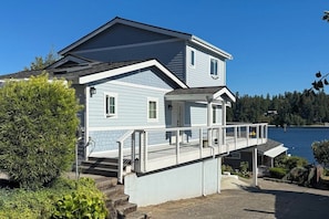 A two-story house with a covered porch and a view of a lake. - Centrally located 2BR Oceanview - Fireplace (Suquamish)