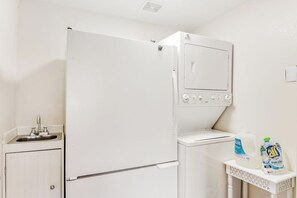 A compact kitchenette with a refrigerator, a microwave, a sink, and a small table with cleaning supplies. - Amazing 3BR Bayview Dog Friendly - Balcony (Allyn)