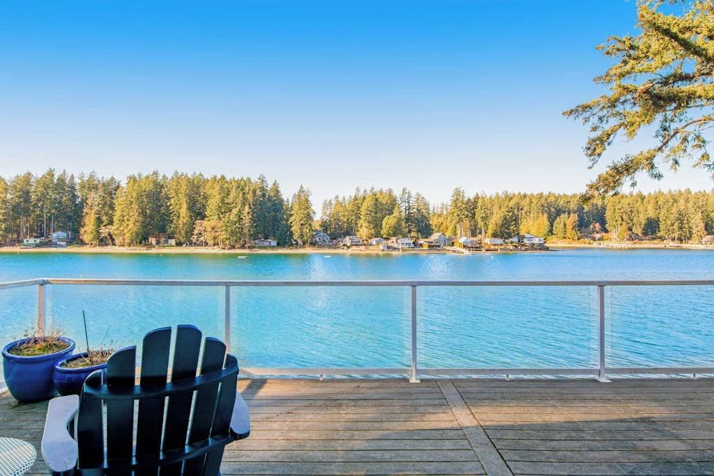 A wooden deck with a view of a lake and forest.
