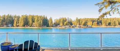 A wooden deck with a view of a lake and forest.