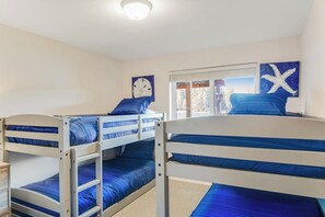 A room with bunk beds, a clock, starfish artwork, and a window with a view. - Amazing 3BR Bayview Dog Friendly - Balcony (Allyn)