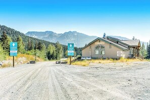 A cabin with a dirt road leading to it, surrounded by forest and mountains. - Dog-friendly, mountainview 1BR- walk to skiing (Snoqualmie Pass)
