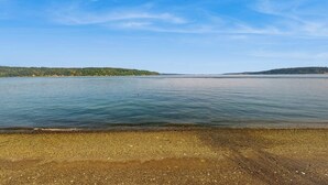 A calm lake with a clear sky and distant land.