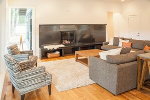 A living room with a fireplace, a sofa set, and a coffee table. - 4BR tree-lined manor with hot tub, firepit, grill (Cle Elum)