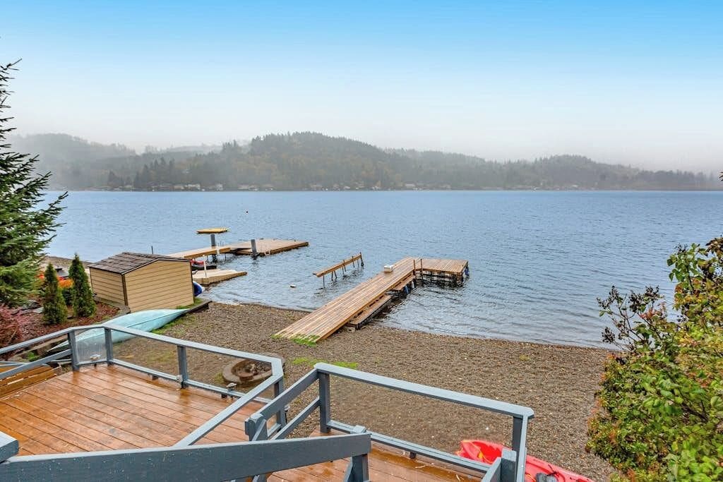A lakeside deck with wooden walkways leading to docks, a small shed, and a clear view of the water.