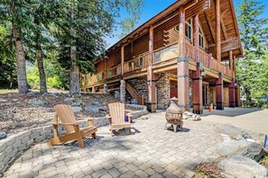 Eine Blockhütte mit Stein Fundament, mehreren Balkonen und einem Kamin aus Stein.
