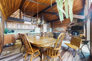 Un interior rústico de madera con comedor, cocina y zona de estar.