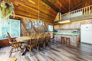 Un interior de madera con comedor, cocina y una escalera.