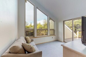 A room with a sofa, a desk, and large windows. - 3BR Dog Friendly - Hot Tub - Fireplace (Westport)