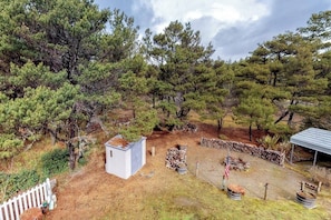 A fenced outdoor area with trees, a small shed, and a stone wall. - 3BR Dog Friendly - Hot Tub - Fireplace (Westport)