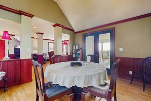 A dining area with a round table, chairs, and a view of the outdoors. - 4 BR home with foosball table, gym, and large yard (Indianola)