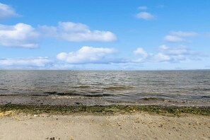 A beach with a sandy shore and calm water. - 3BR beachfront paradise with outstanding views (Sequim)