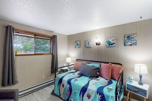 Ein Schlafzimmer mit einem Bett, einem Nachttisch, einer Lampe und Wandbildern.