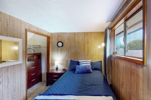 A bedroom with a bed, a nightstand, a dresser, and a mirror. - Peaceful 3BR Oceanview Dog Friendly - Deck (Grayland)