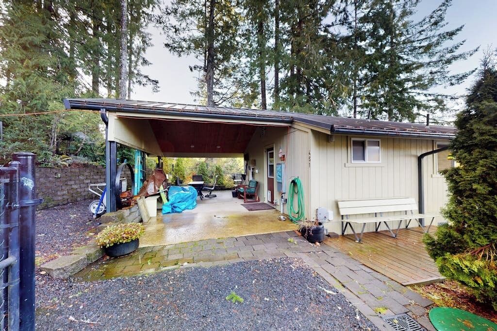 A single-story house with a covered porch, a small deck, and a garage.