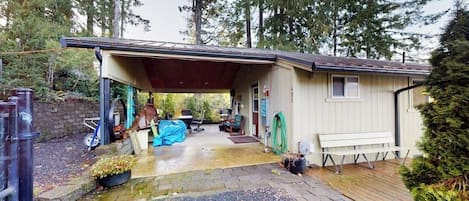 A single-story house with a covered porch, a small deck, and a garage.
