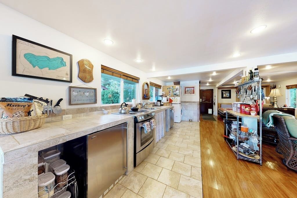 A kitchen with a dishwasher, oven, and a countertop with various items.