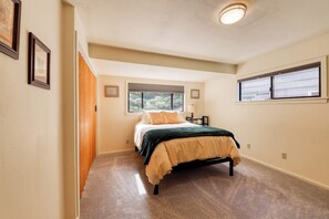 A bedroom with a bed, a window, and a door. - Incredible 3BR Bayview Dog Friendly - Dock (Gig Harbor)