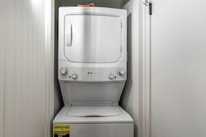 Una lavadora y secadora compactas de color blanco, con panel de control y puerta frontal.