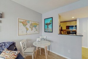Un espacio habitable compacto con comedor, cocina y un mapa mundial en la pared.