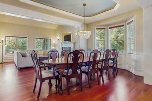 A dining area with a round table and chairs, a chandelier, and large windows with blinds. - 4BR Enumclaw home-AC-grill-fireplace-walk to town (Enumclaw)