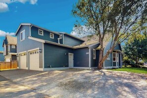 Une maison à deux étages avec un garage, une véranda et une allée.