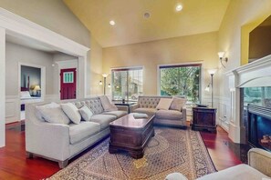A spacious living room with a fireplace, a large rug, and a sofa set. - 4BR Enumclaw home-AC-grill-fireplace-walk to town (Enumclaw)