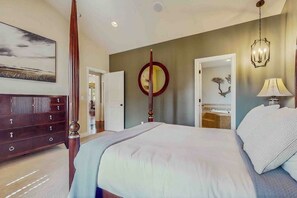 Une chambre à coucher avec un lit à baldaquin, une commode, un miroir et un lustre.