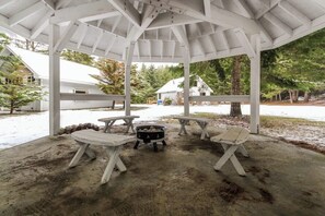 A covered outdoor area with picnic tables and a fire pit. - Stylish 3BR - Fireplace - Deck - Washer Dryer (Cle Elum)