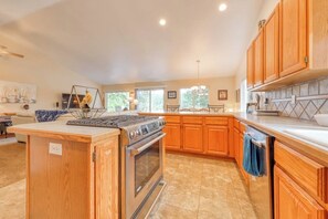 A kitchen with wooden cabinets, a central island, and a built-in oven.