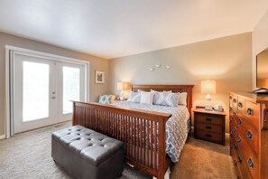 A bedroom with a bed, a nightstand, a dresser, and a bench.