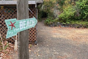 A directional sign with a red star, pointing towards the beach.
