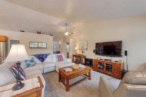 A living room with a sofa, coffee table, TV, and fireplace.