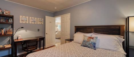 Une chambre à coucher avec un lit, un bureau, une chaise et une bibliothèque.