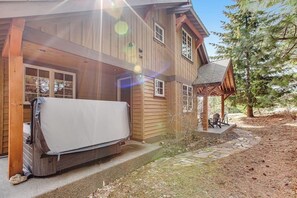 Ein Holzhaus mit überdachter Veranda und einer Matratze davor.