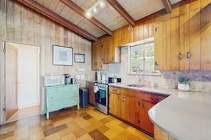 A kitchen with wooden cabinets, a stove, and a window. - 3 BR Waterfront home in the heart of Gig Harbor (Gig Harbor)