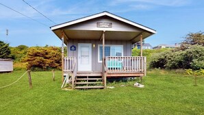 A small, single-story building with a porch and a sign that reads 'Driftwood Cottage.' - 2BR Oceanview Dog Friendly | Deck | Fireplace (Moclips)