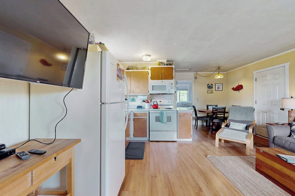 Un espacio habitable compacto con kitchenette, comedor y zona de estar.